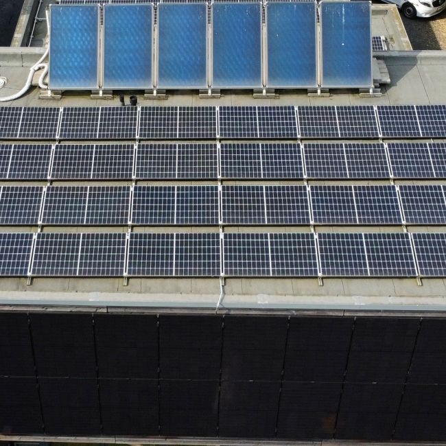 Galerie mit zwei Bildern: Links Solaranlage mit Photovoltaik- und Röhrenkollektoren auf Flachdach, rechts vier Solarthermie-Kollektoren auf Ziegeldach.