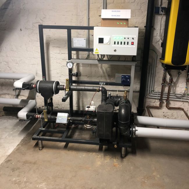 Galerie mit drei Bildern: Technische Installationen in einem Heizungskeller mit Pumpengruppen, Steuerungseinheit und rotem Druckausgleichsbehälter.